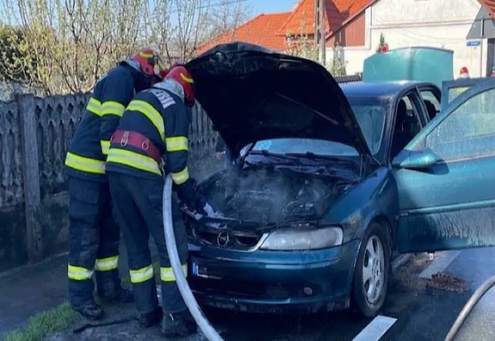 Maşină cuprinsă de flăcări pe o stradă din Aleşd! Mai mulţi şoferi au încercat să stingă incendiul (FOTO)